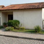 Casa brasileira em bairro residencial ilustrando compra segura de imóvel e certidão de ônus reais