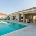 Área comum de condomínio com piscina e churrasqueira para reserva
