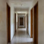 Corredor de condomínio com manchas de vazamento de água no teto