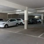 Garagem compartilhada em prédio residencial brasileiro com carros estacionados