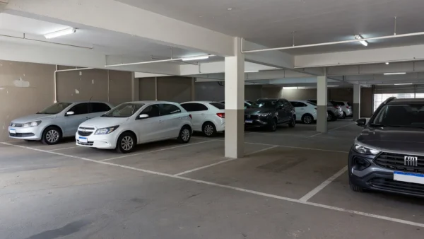 Garagem compartilhada em prédio residencial brasileiro com carros estacionados