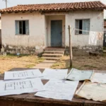 Casa brasileira com documentos de imóvel representando verificação de usucapião
