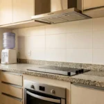 Cozinha brasileira com cooktop, forno e coifa instalados de forma organizada e espaçosa