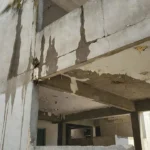 Manchas de infiltração em parede e teto de condomínio residencial brasileiro