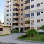 Condomínio residencial brasileiro com prédio de apartamentos e área de entrada