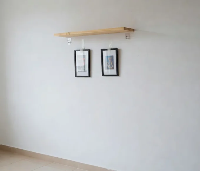 Prateleira e quadros pendurados em parede de apartamento alugado sem danificar a superfície